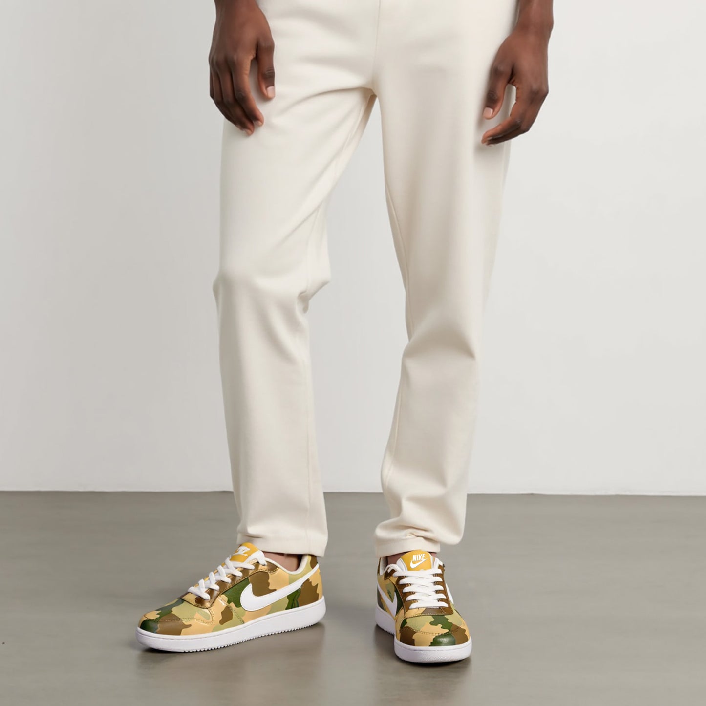 Person wearing hand-painted camouflage sneakers with a Nike logo on a neutral background