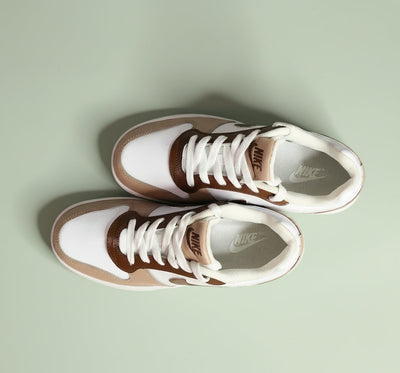 A hand-painted Pair of Nike sneakers with brown and beige design on a light green background