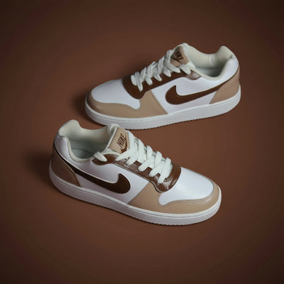 Pair of hand-painted brown and beige sneakers with Nike logo on a brown background