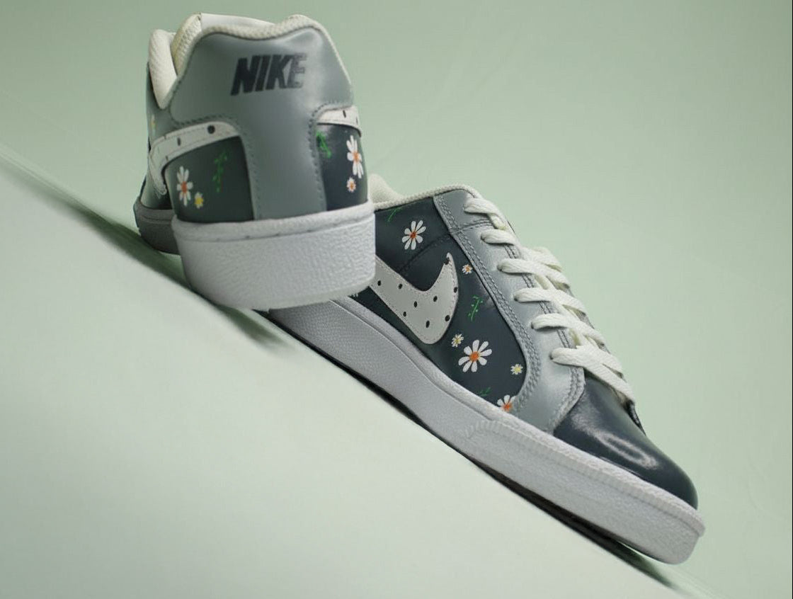 Custom painted grey sneaker with white, orange, yellow floral patterns on  a light green background 