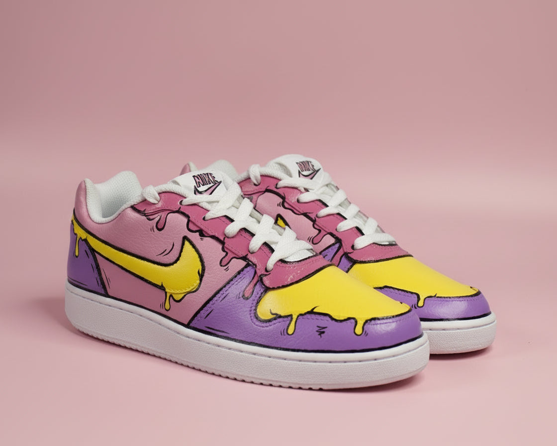 Hand-painted colourful (pink, purple and yellow) Nike sneakers with cartoonish lines and melted effect design on a light pink background