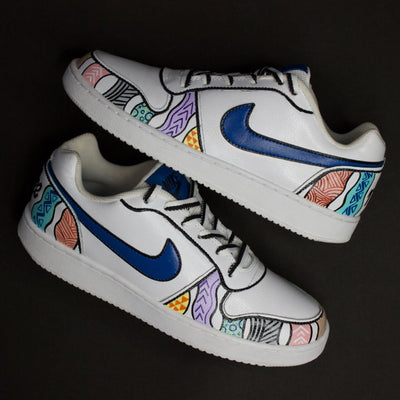 A hand-painted White sneakers with colourful patterns and blue Nike logo on a black background