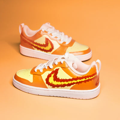Hand-painted orange and yellow sneakers with a prominent Nike logo on an orange background