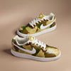 Hand-painted sneakers with camouflage colour pattern with shades of green and brown  on a light bronze background